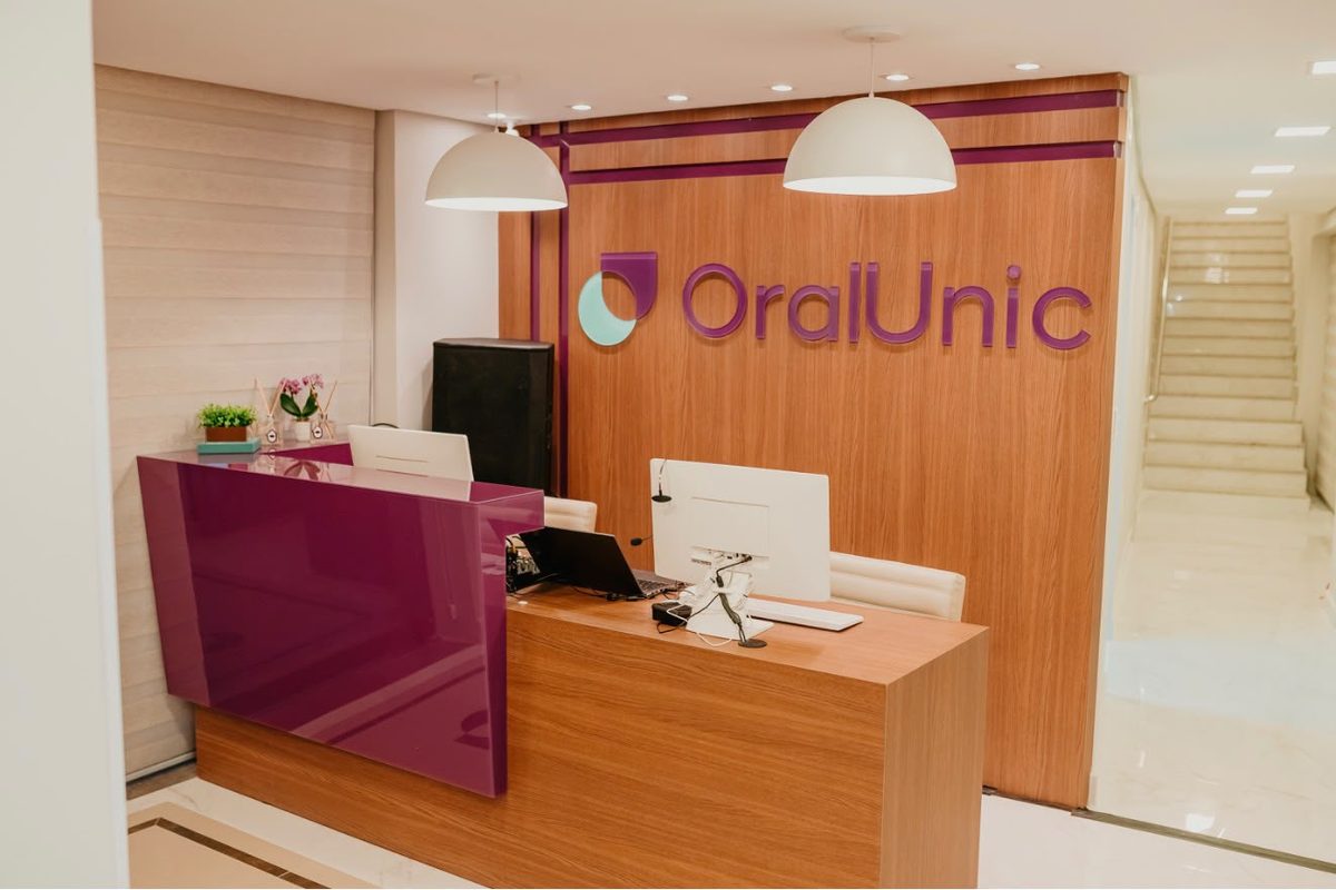 Recepção da Oral Unic Carlos Barbosa, com o logo da rede no balcão